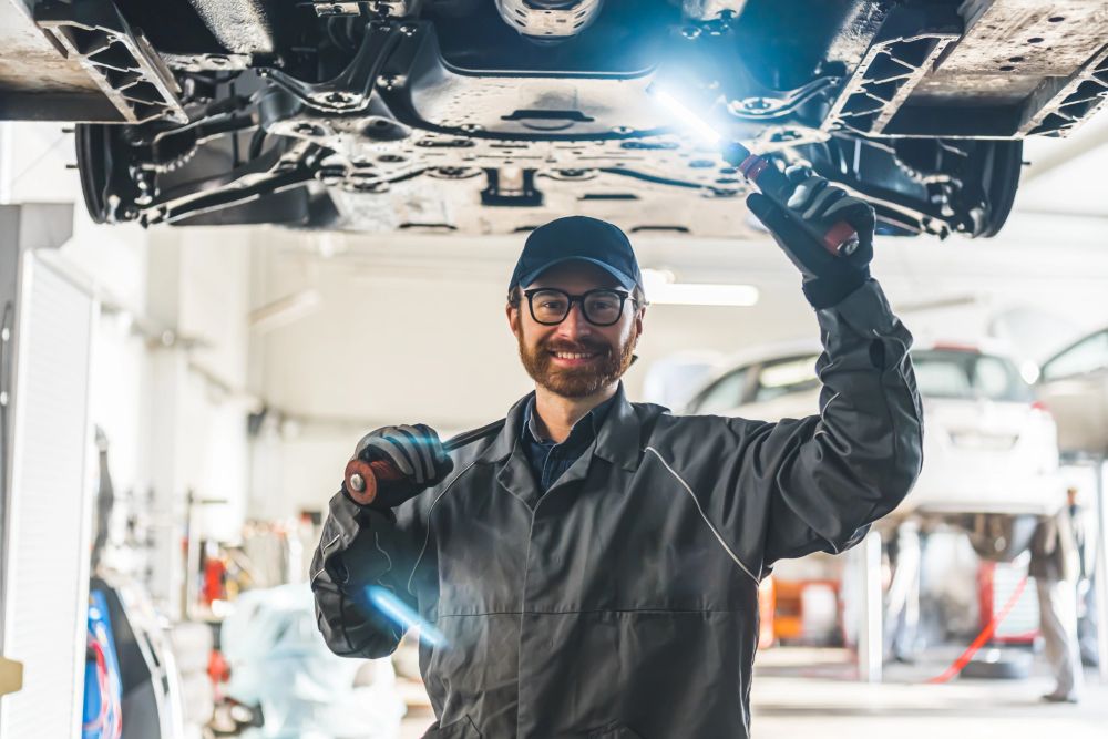 Mechanic inspecting a vehicle in an auto repair workshop